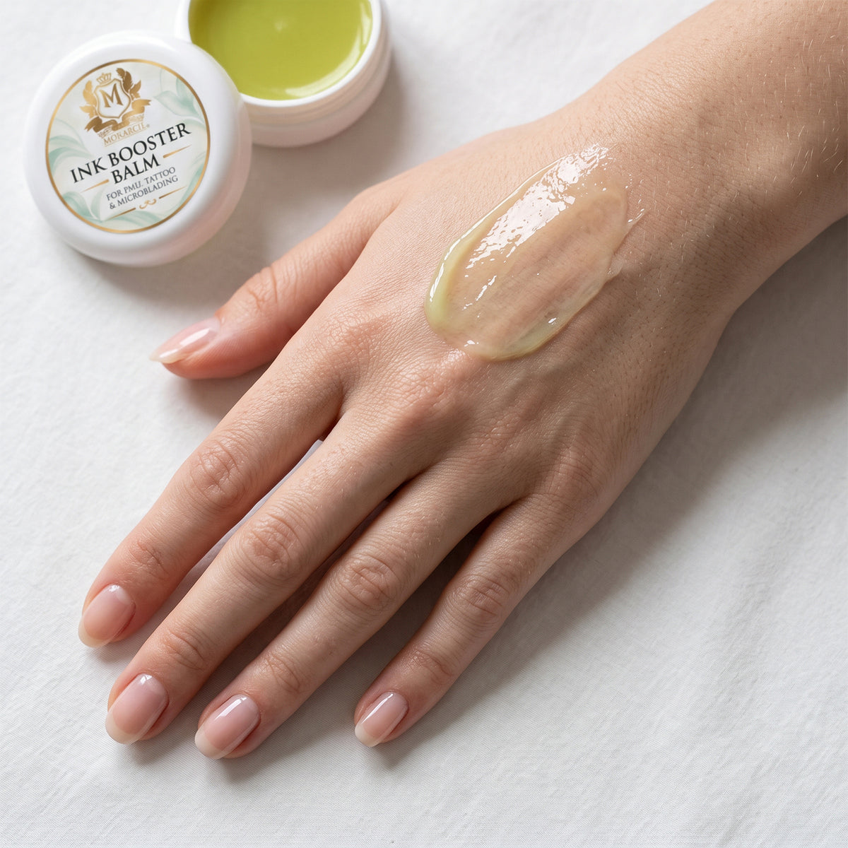 Skin Monarch Ink Booster Balm 30ml, glossy balm spread on the back of a hand
